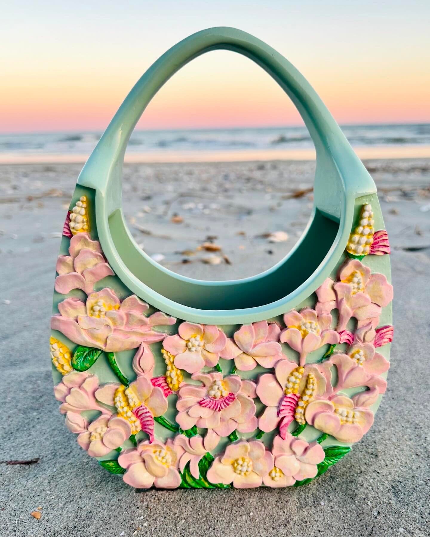 Blumera’s most beloved tote—pastel hand-painted and carved from wood—glowing on the beach at sunset in limited edition beauty.