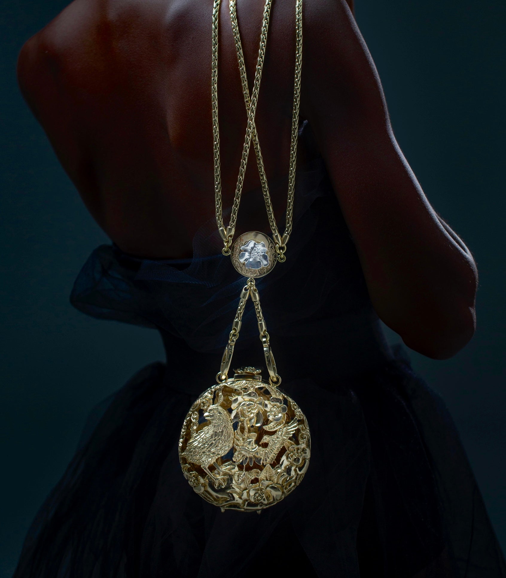 Model carrying a brass Blumera bag in dramatic lighting, highlighting wearable luxurious art and sculptural craftsmanship. Ultimate High Fashion.