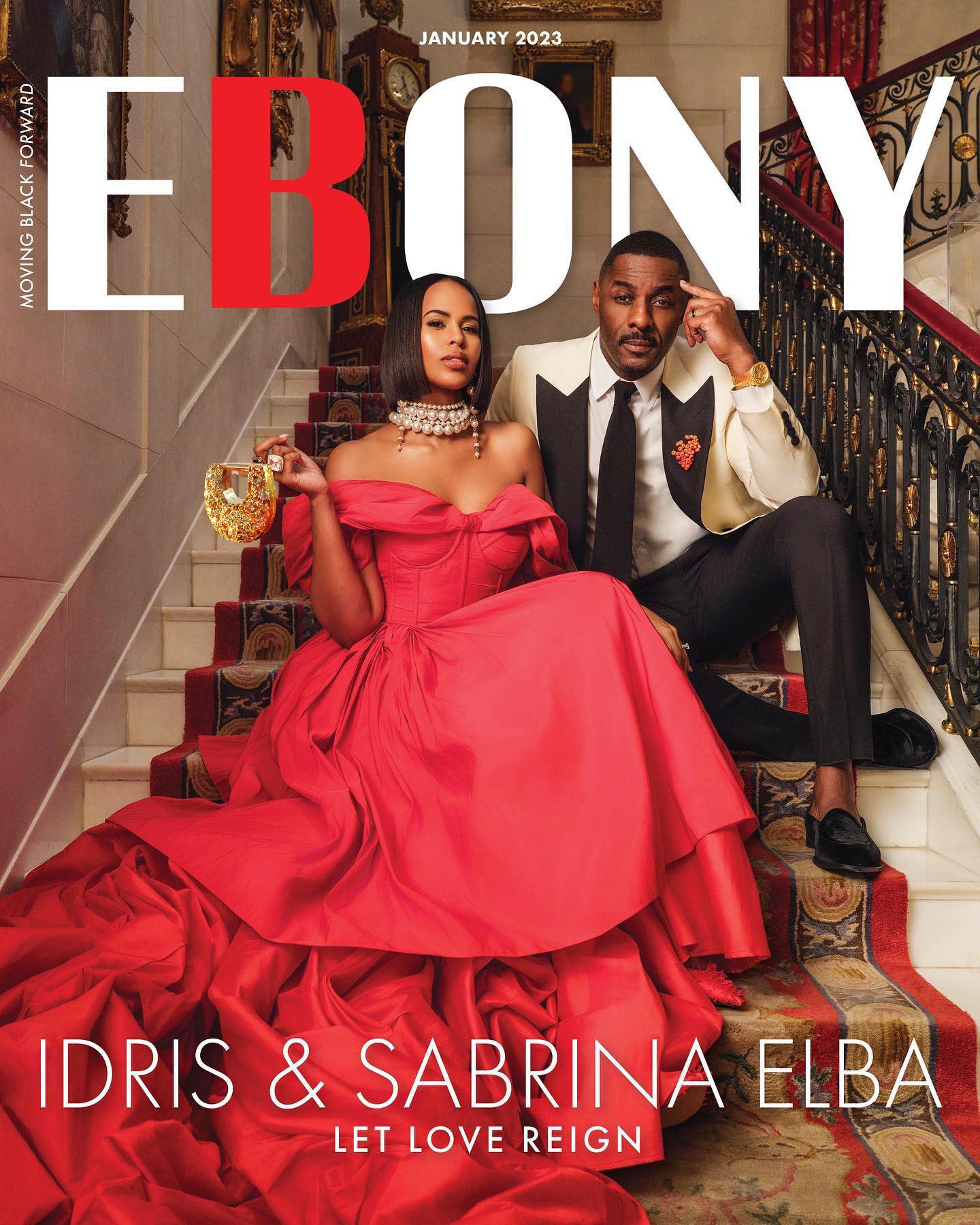 Sabrina Elba holding a brass Blumera bag on the Ebony cover with Idris Elba, styled in high fashion.