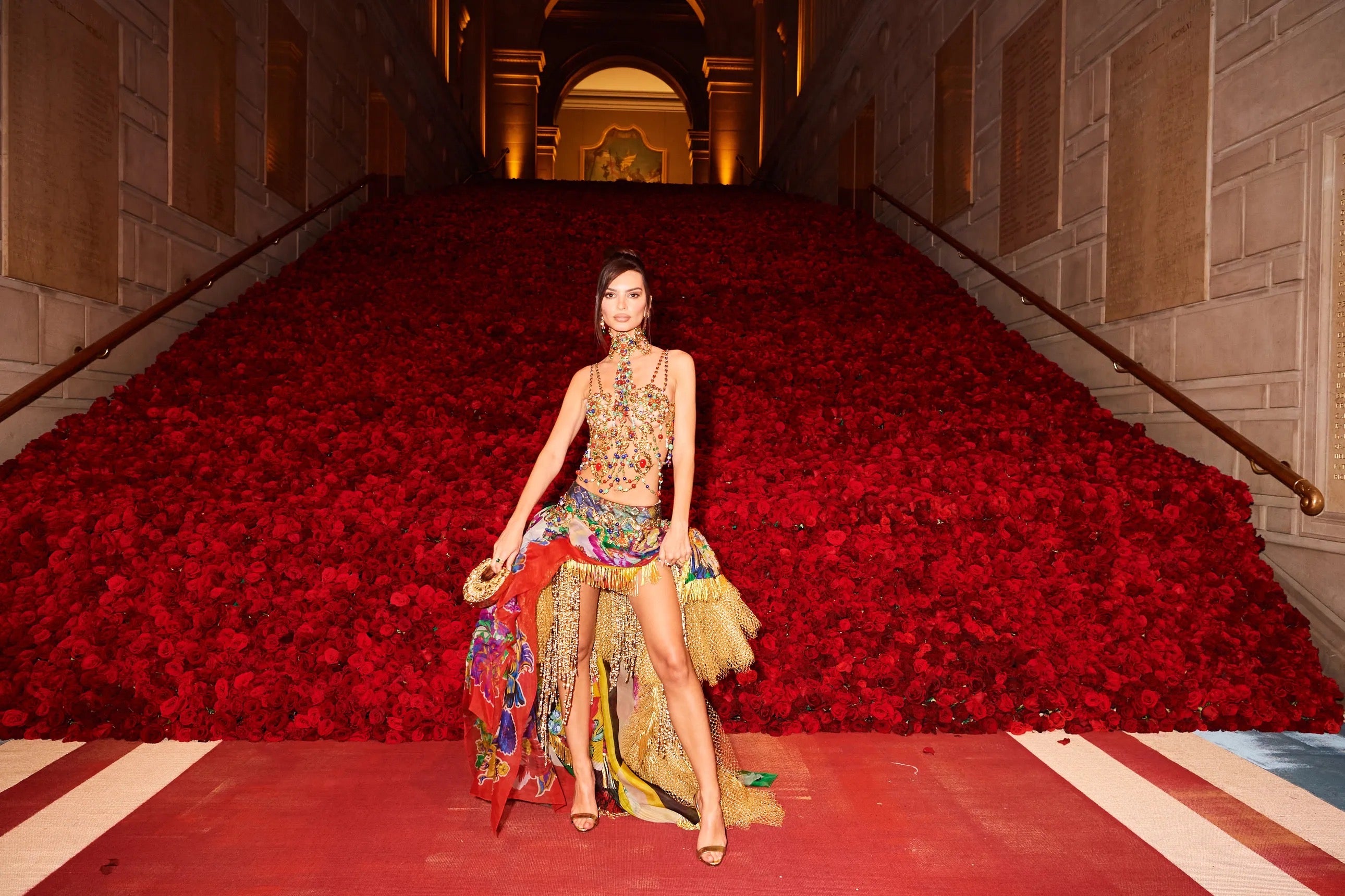 Emily Ratajkowski at the Met Gala carrying the hand-carved brass mini u simurgh and hummingbirds Blumera bag, wearing archival Versace.